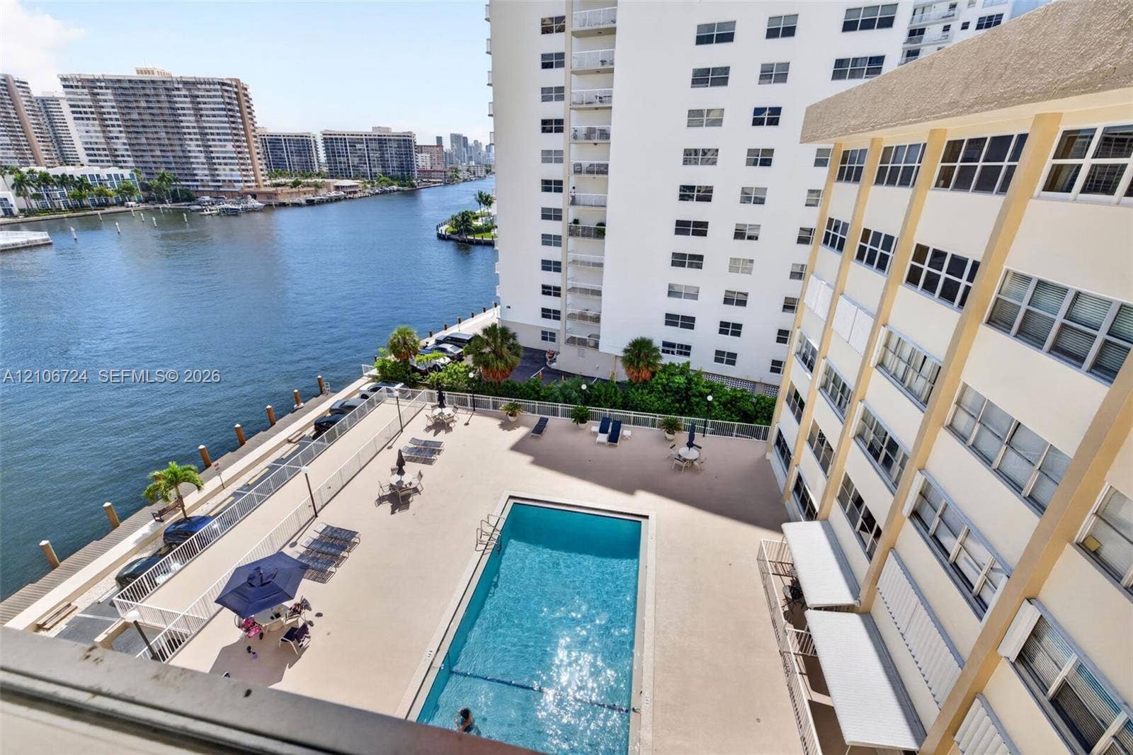 111 Golden Isles Drive, #G12, Hallandale Beach, FL 33009 Waterfront swimming pool with concrete deck and metal perimeter fencing