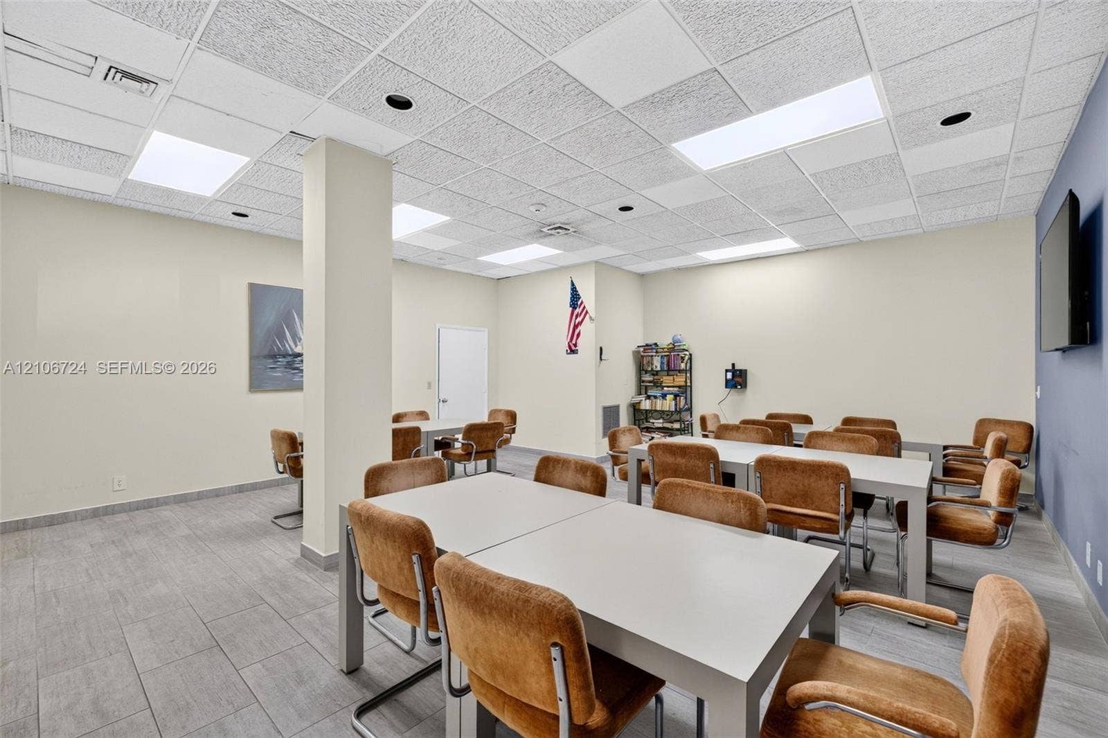 111 Golden Isles Drive, #G12, Hallandale Beach, FL 33009 Open-concept interior featuring drop ceiling tiles with recessed lighting, structural support column, and gray tile flooring