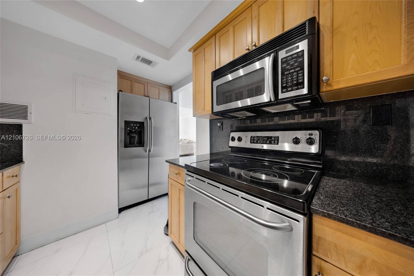 1200 West Avenue, #606, Miami Beach, Miami Beach, FL 33139 Kitchen featuring natural-finish wood cabinetry, stone countertops, stainless steel appliances, and tile flooring