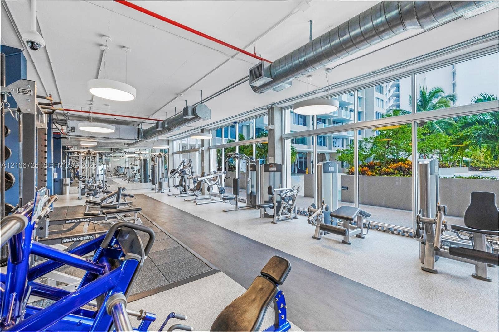 1200 West Avenue, #606, Miami Beach, Miami Beach, FL 33139 Fitness center featuring floor-to-ceiling windows, exposed industrial-style ductwork, recessed drum pendant lighting, and rubberized flooring