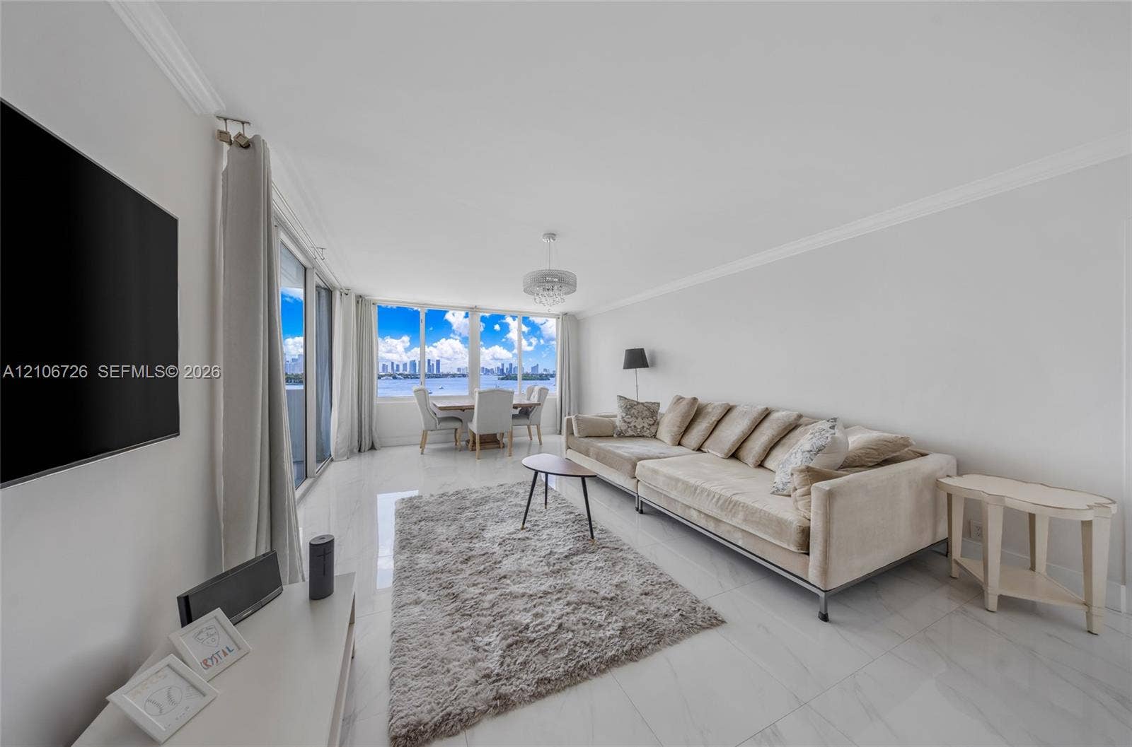 1200 West Avenue, #606, Miami Beach, Miami Beach, FL 33139 Open-concept living area featuring polished tile flooring, floor-to-ceiling windows, crown molding, and a drum-style ceiling light fixture