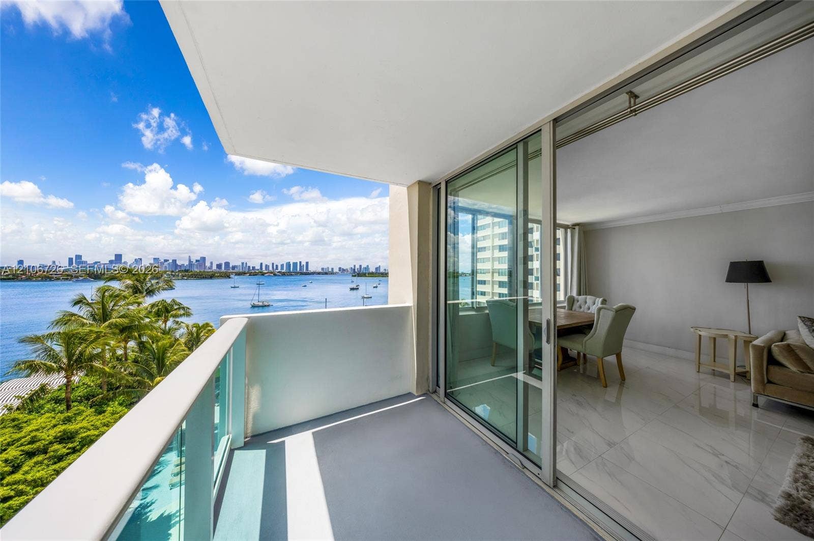 1200 West Avenue, #606, Miami Beach, Miami Beach, FL 33139 Private balcony featuring a partial glass-panel railing, floor-to-ceiling sliding glass doors, and polished stone-finish flooring
