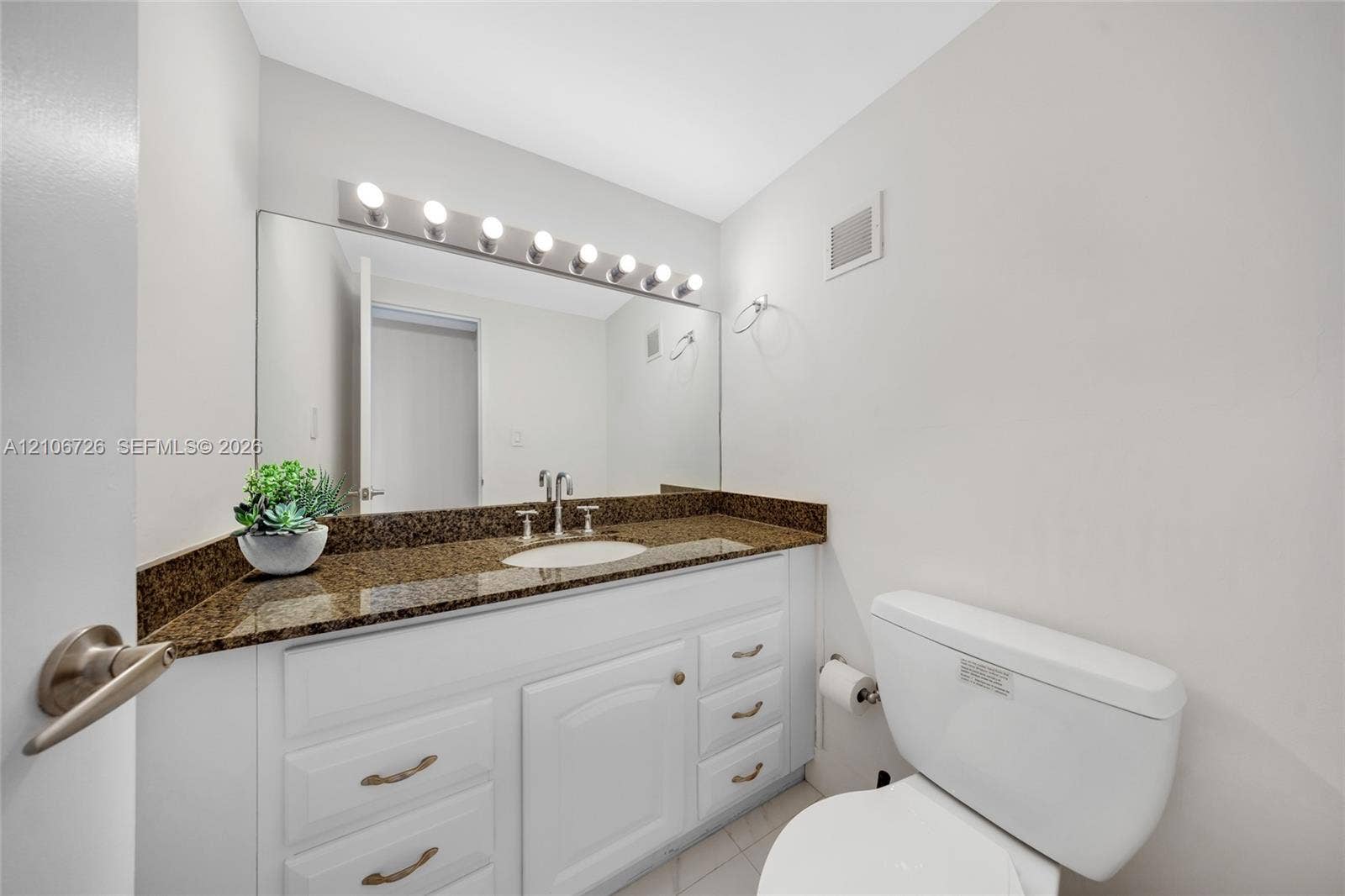 1200 West Avenue, #606, Miami Beach, Miami Beach, FL 33139 Bathroom featuring a white vanity with multi-drawer storage, stone-finish countertop, integrated undermount sink, and full-width vanity mirror with integrated light fixture
