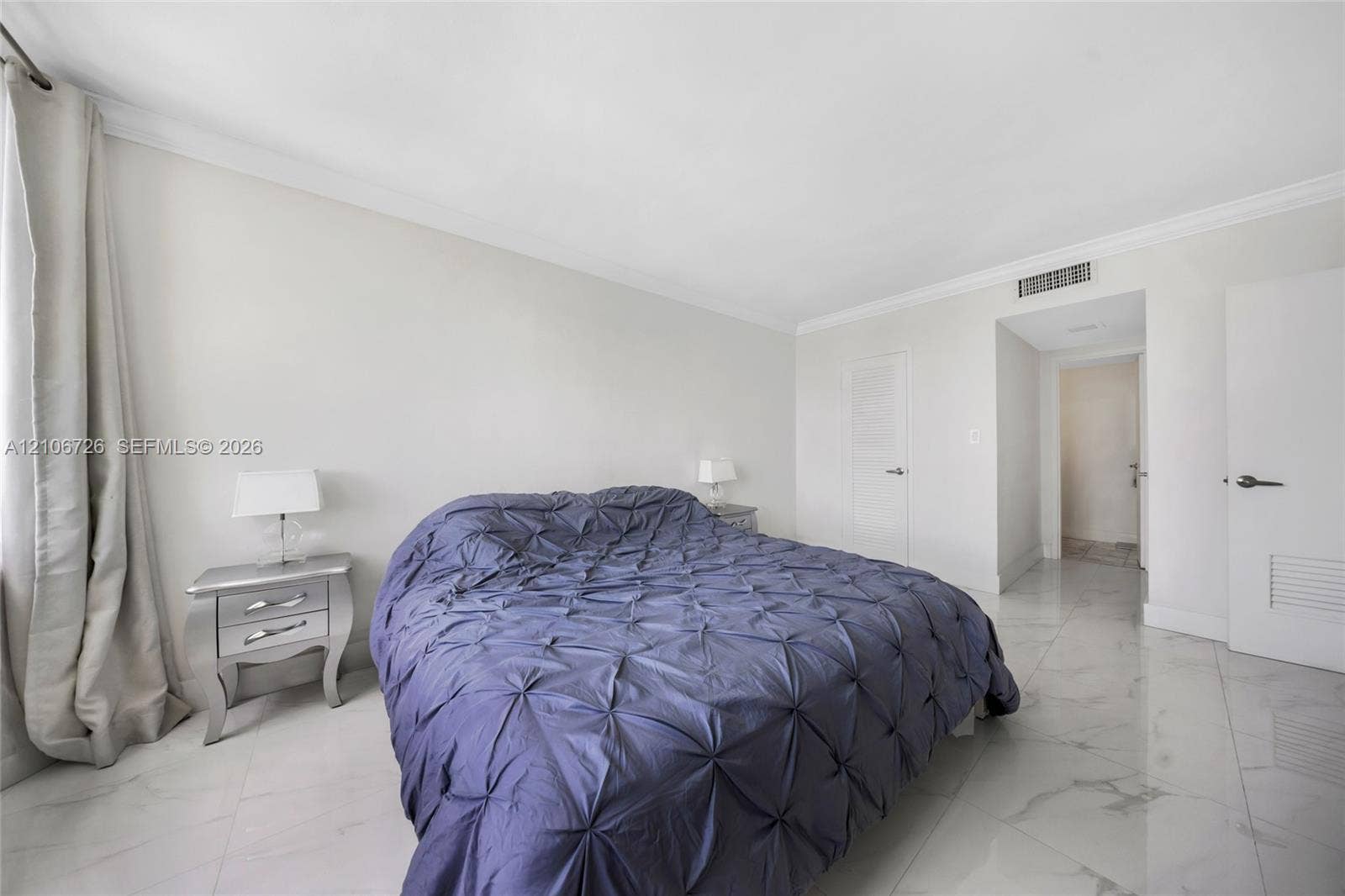 1200 West Avenue, #606, Miami Beach, Miami Beach, FL 33139 Spacious room featuring polished tile flooring, neutral wall tones, crown molding, and solid-core doors with brushed nickel hardware