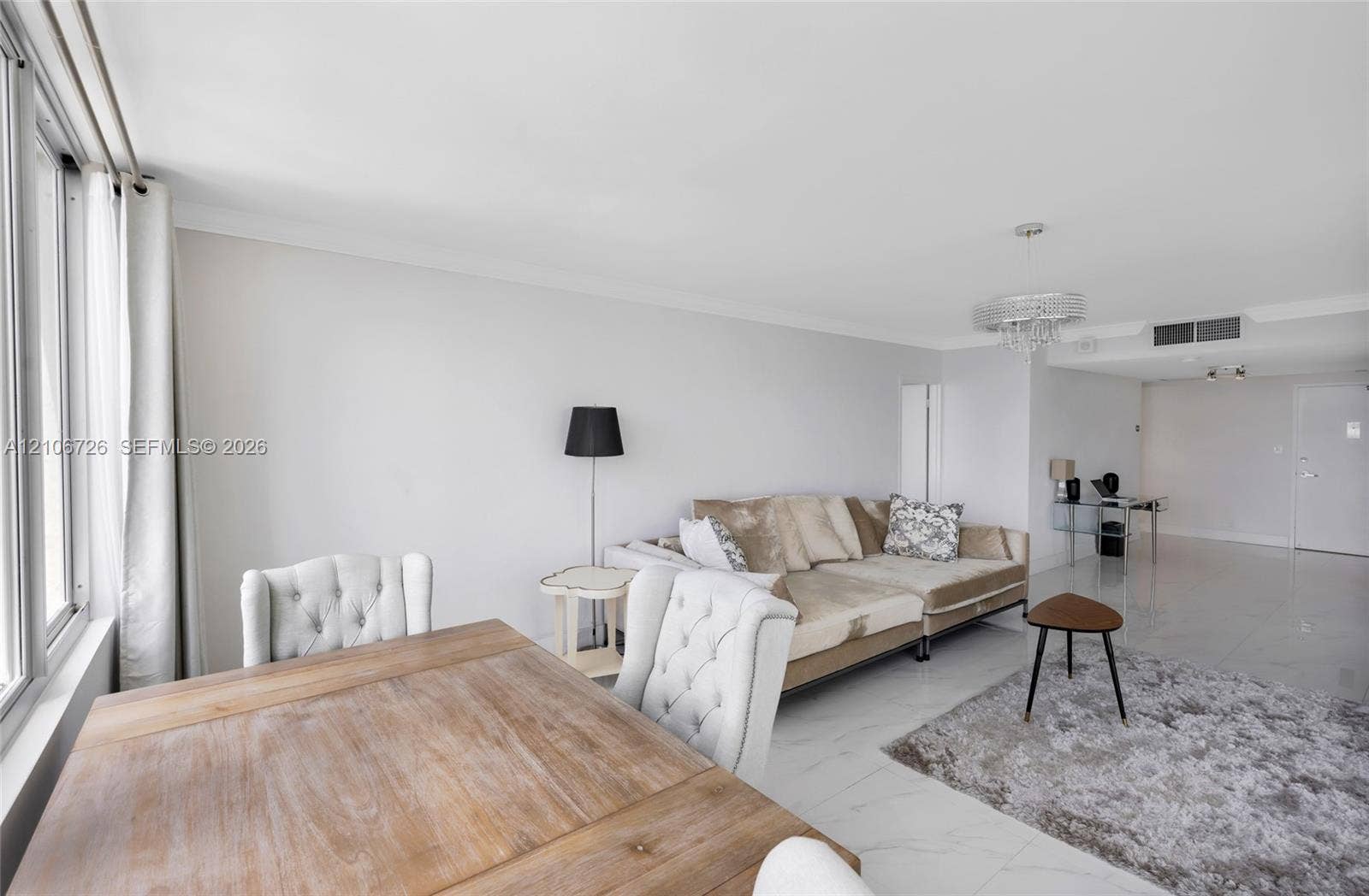 1200 West Avenue, #606, Miami Beach, Miami Beach, FL 33139 Open-concept interior featuring large-format tile flooring, crown molding, a crystal chandelier, and floor-to-ceiling windows