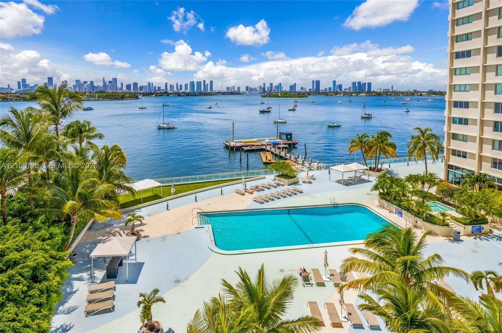 1200 West Avenue, #606, Miami Beach, Miami Beach, FL 33139 Swimming pool with expansive deck, boat dock, and waterfront positioning featuring palm trees and city skyline backdrop