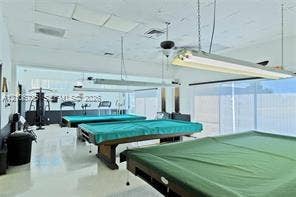 1000 SW 11 Avenue, #12, Hallandale Beach, Hallandale Beach, FL 33009 Open-concept room featuring smooth-finish flooring, drop-ceiling grid panels, and dual suspended fluorescent lighting fixtures