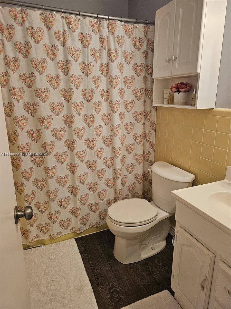 1000 SW 11 Avenue, #12, Hallandale Beach, Hallandale Beach, FL 33009 Bathroom featuring wood-finish flooring, square ceramic wall tiling, white vanity cabinet with integrated sink, and white wall-mounted storage cabinetry