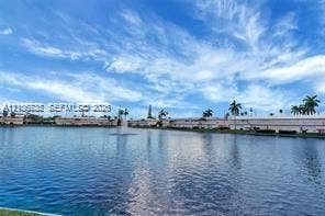 1000 SW 11 Avenue, #12, Hallandale Beach, Hallandale Beach, FL 33009 Waterfront lot featuring a wide expanse of water, a central fountain, and surrounding mature palm trees