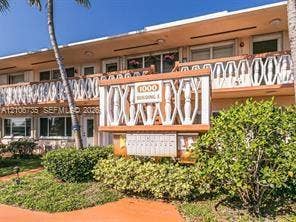 1000 SW 11 Avenue, #12, Hallandale Beach, Hallandale Beach, FL 33009 Mid-century exterior featuring decorative latticed balcony railings, clean stucco facade, and established tropical landscaping