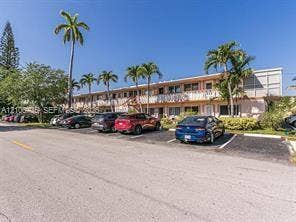 1000 SW 11 Avenue, #12, Hallandale Beach, Hallandale Beach, FL 33009 Multi-story exterior featuring a balcony railing system, concrete parking area, and mature palm trees