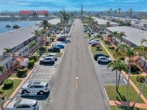 1000 SW 11 Avenue, #12, Hallandale Beach, Hallandale Beach, FL 33009 Aerial perspective of the residential community featuring low-rise buildings, designated surface parking, mature palm trees, and waterfront grounds
