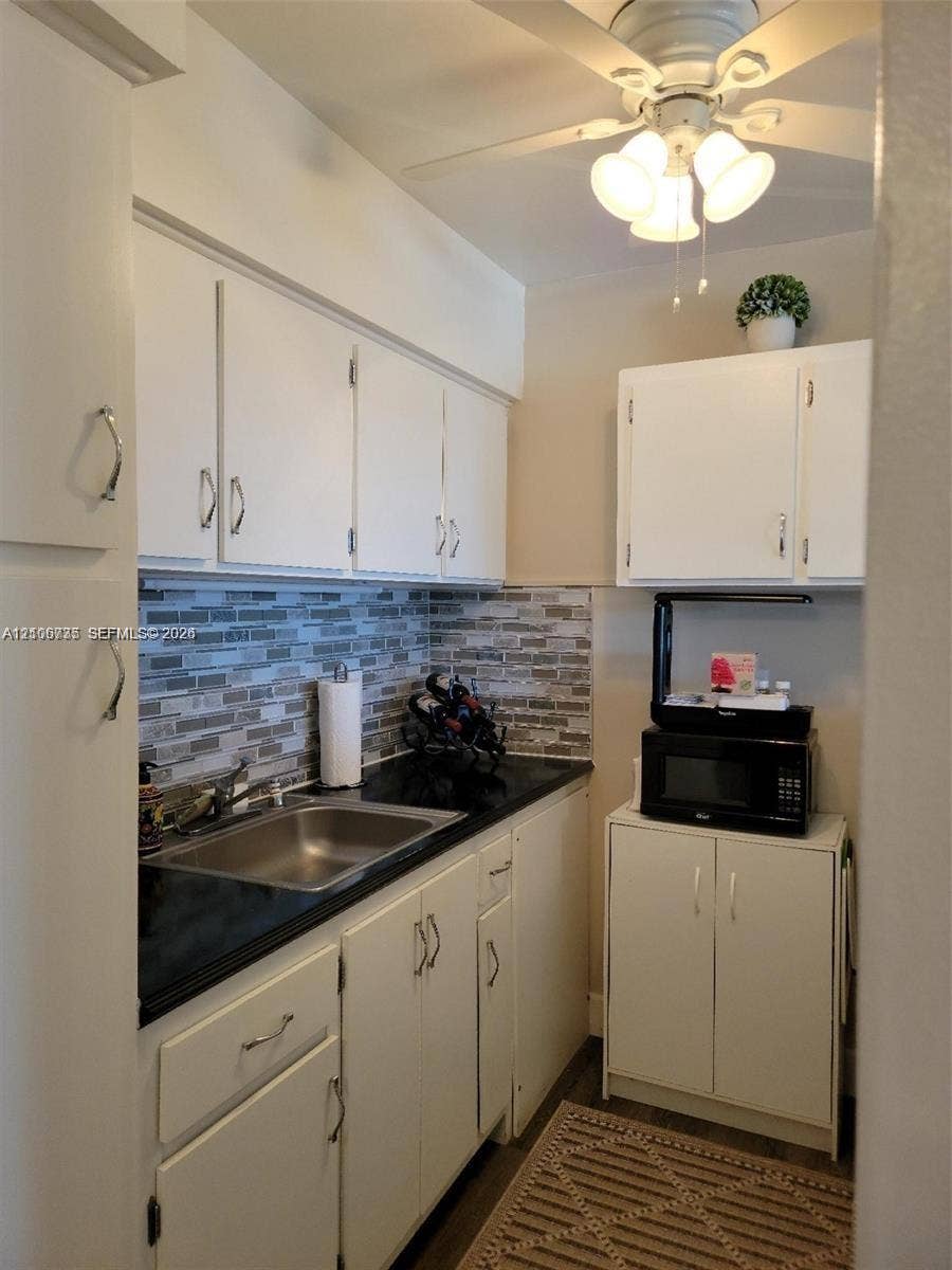 1000 SW 11 Avenue, #12, Hallandale Beach, Hallandale Beach, FL 33009 Kitchenette featuring white cabinetry, dark stone-finish countertops, stainless steel sink, multi-tonal linear tile backsplash, and a ceiling-mounted light fixture