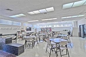 1000 SW 11 Avenue, #12, Hallandale Beach, Hallandale Beach, FL 33009 Open-plan interior space featuring high-gloss flooring, recessed panel lighting, extensive horizontal windows, and a built-in dark masonry tiered platform