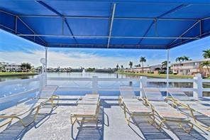 1000 SW 11 Avenue, #12, Hallandale Beach, Hallandale Beach, FL 33009 Covered waterside deck featuring a metal frame awning, white composite railing, and concrete flooring