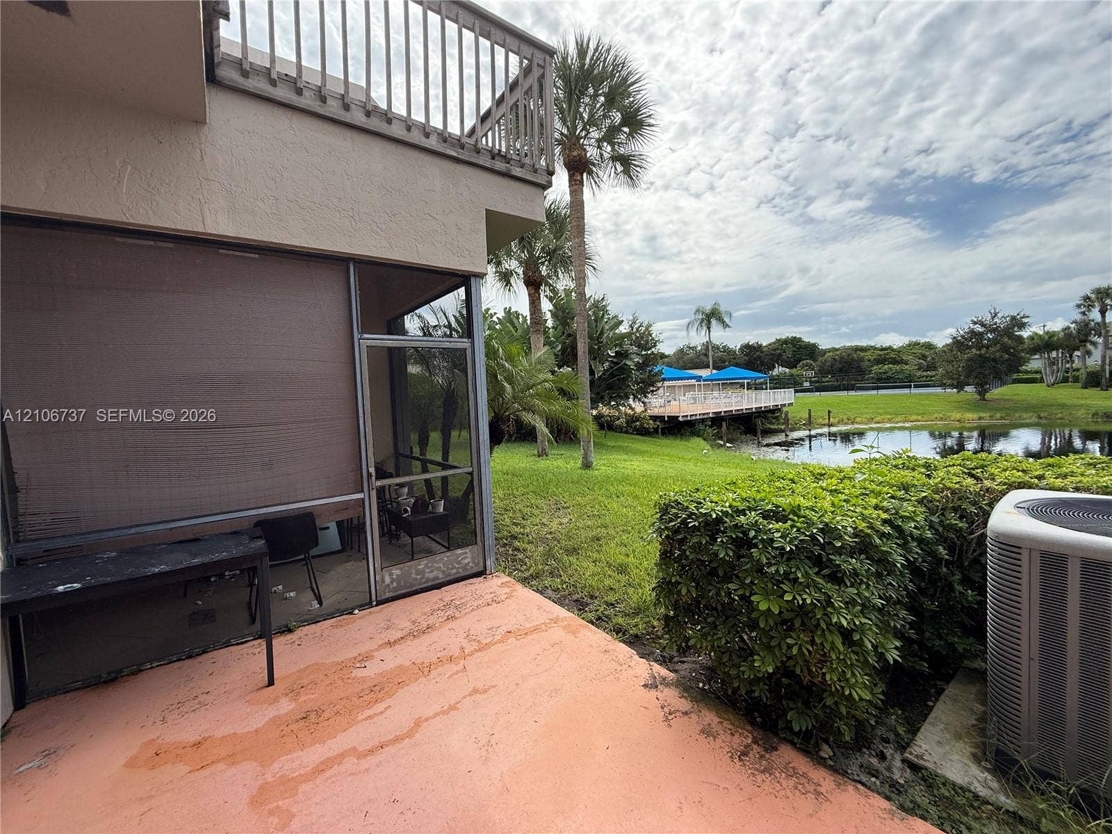 5225 Monterey Circle, #G, Delray Beach, FL 33484 Screened-in patio with concrete flooring, second-story balcony with metal railings, and exterior water frontage