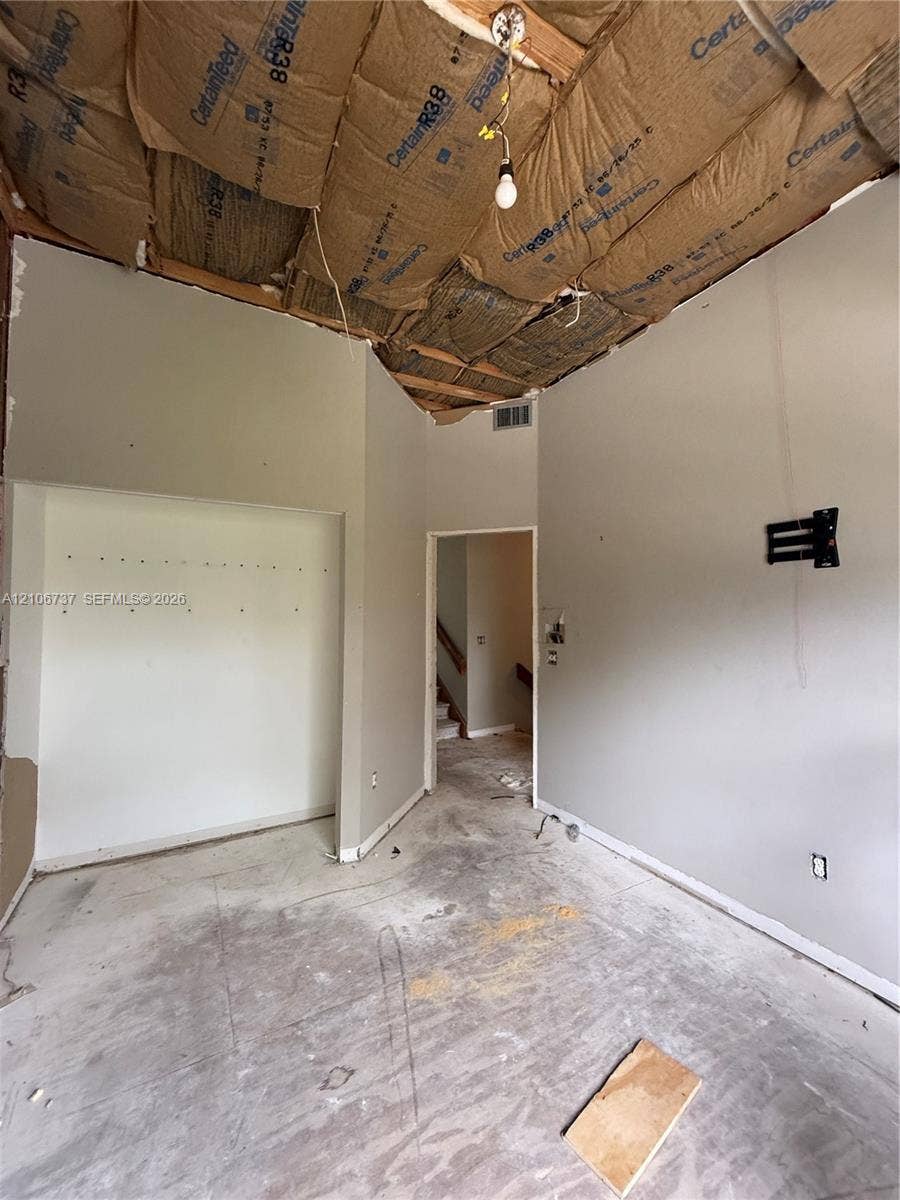 5225 Monterey Circle, #G, Delray Beach, FL 33484 Interior space featuring exposed ceiling insulation, recessed wall niche, and wall-mounted hardware