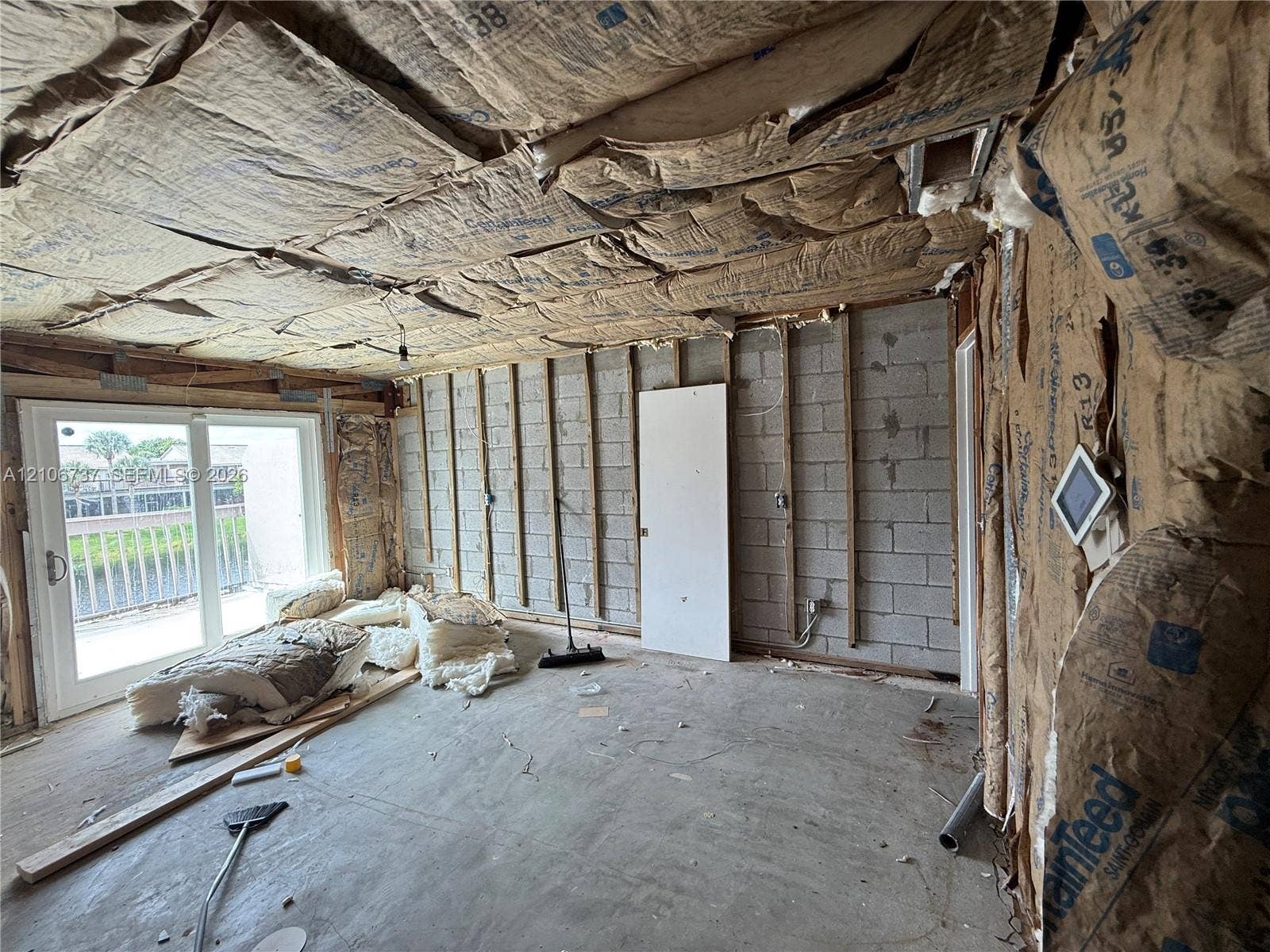 5225 Monterey Circle, #G, Delray Beach, FL 33484 Concrete block wall construction with exposed wall studs, fiberglass batt insulation, and sliding glass door