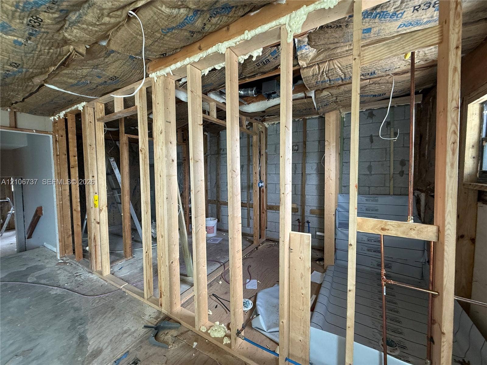 5225 Monterey Circle, #G, Delray Beach, FL 33484 Exposed timber stud wall framing with concrete block masonry foundation, fiberglass batt insulation, and pre-installed shower pan