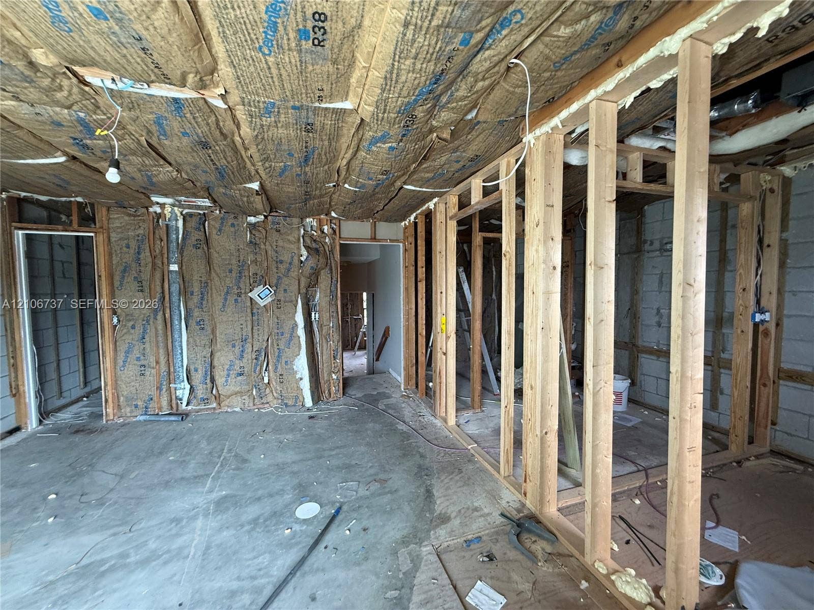 5225 Monterey Circle, #G, Delray Beach, FL 33484 Unfinished interior space featuring exposed wood framing, concrete block walls, and R-38 fiberglass batt ceiling insulation
