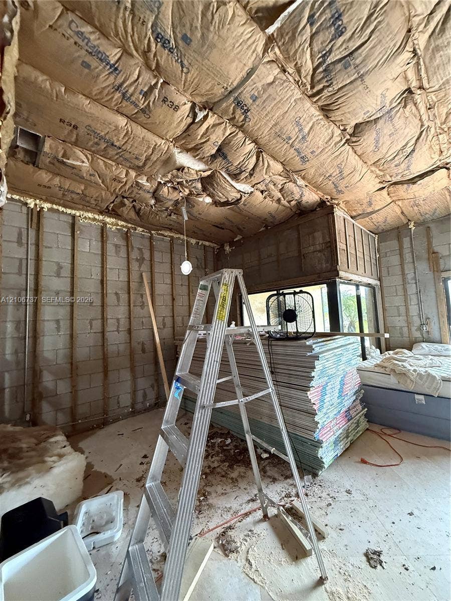 5225 Monterey Circle, #G, Delray Beach, FL 33484 Interior space featuring exposed concrete block walls and ceiling insulation