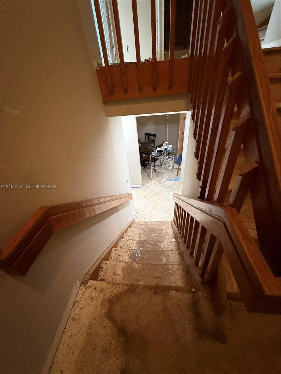 5225 Monterey Circle, #G, Delray Beach, FL 33484 Staircase featuring wood railings, vertical wood balusters, and a mounted wood handrail