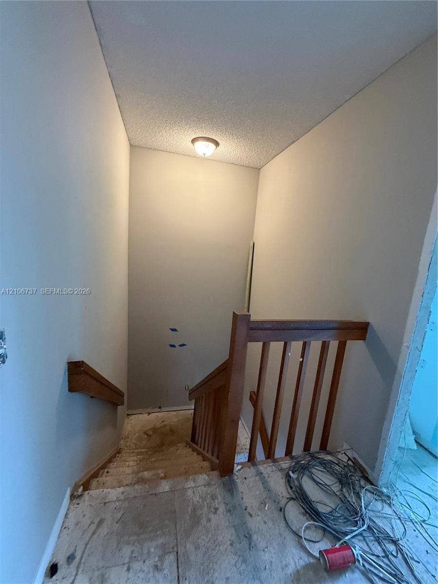 5225 Monterey Circle, #G, Delray Beach, FL 33484 Staircase featuring wood railings and a flush-mount ceiling light fixture