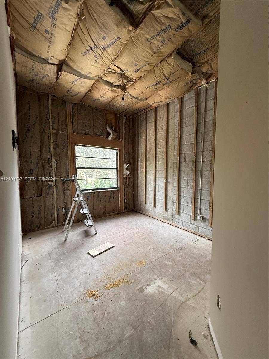 5225 Monterey Circle, #G, Delray Beach, FL 33484 Interior space featuring concrete block construction, exposed wall framing, fiberglass batt insulation, and a single-pane window
