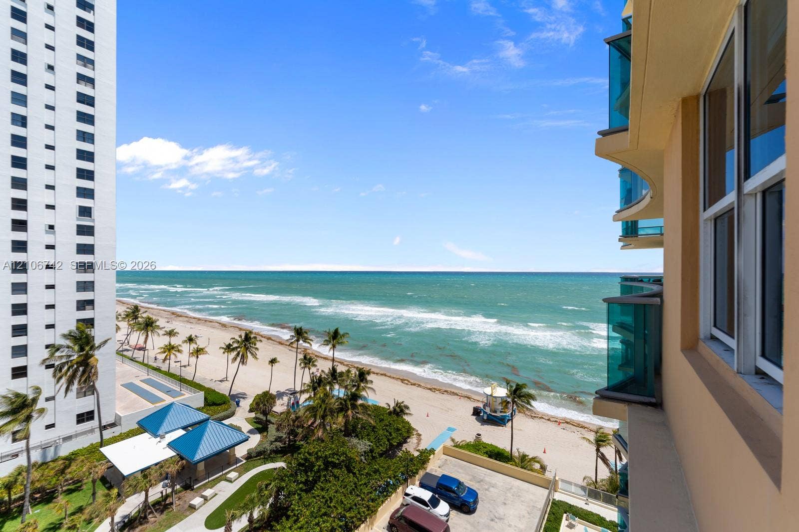 Elevated balcony featuring glass-panel railings and direct ocean frontage