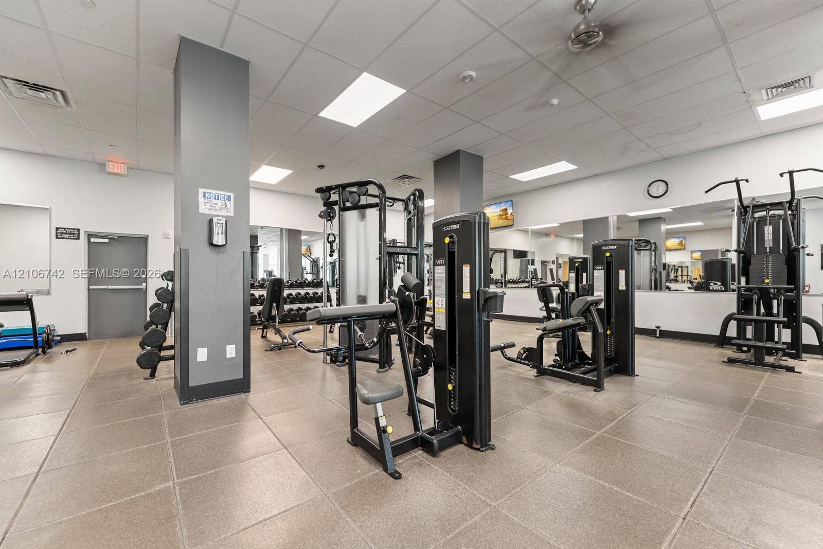 Fitness center featuring large-format tile flooring, mirrored walls, recessed lighting, and a ceiling-mounted fan