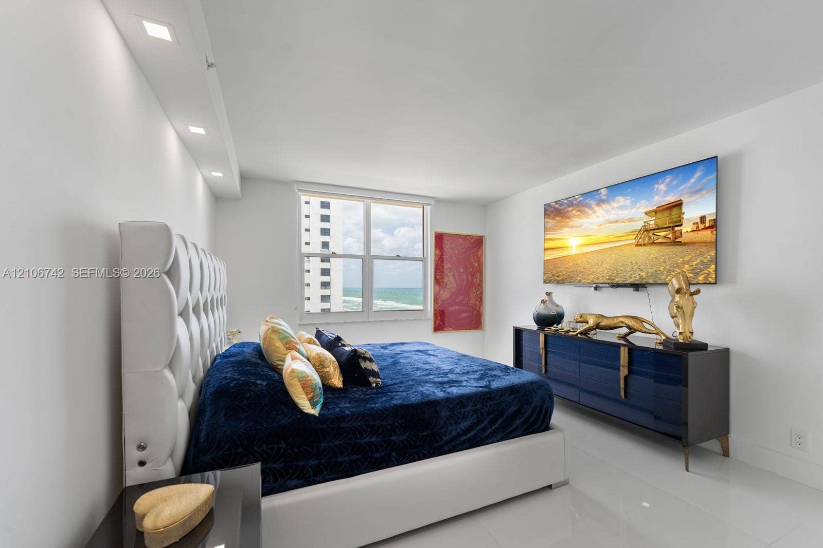Polished tile flooring, recessed ceiling lighting, and expansive dual-pane windows with ocean scenery
