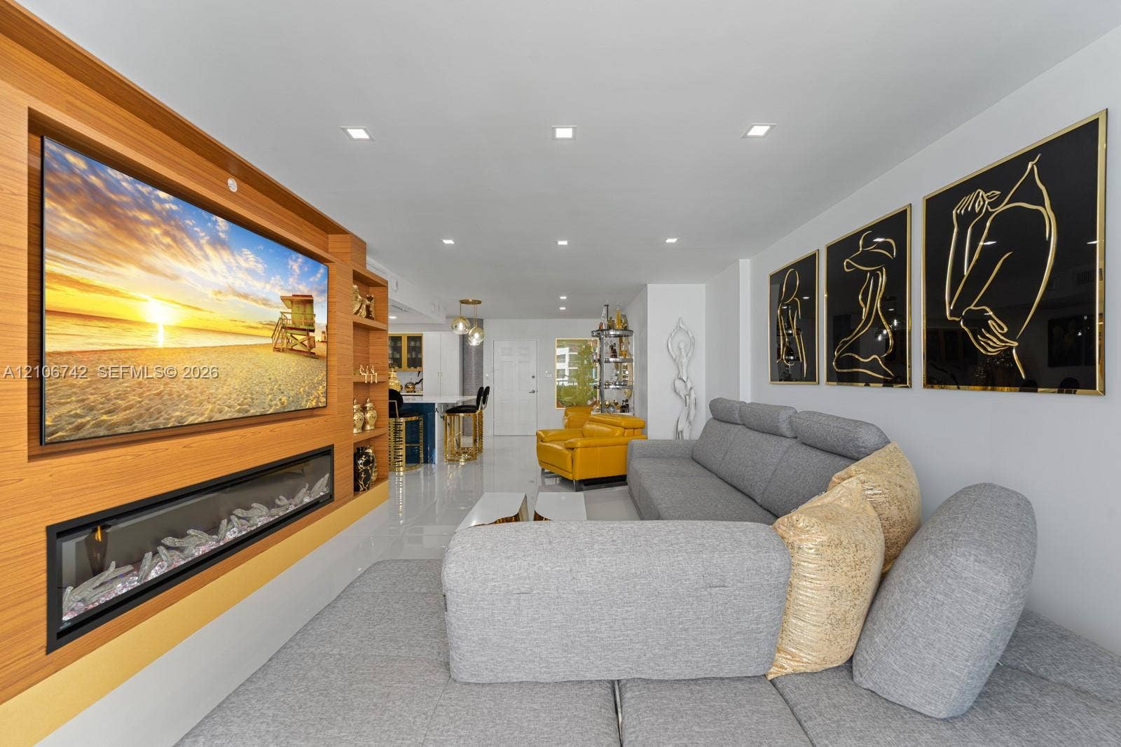 Built-in wood-finish wall unit featuring an integrated media space and linear electric fireplace, complemented by polished tile flooring and recessed lighting