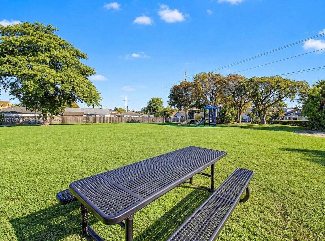 14658 SW 126th Place, Miami, FL 33186 Expansive lawn featuring mature trees, wood privacy fencing, and a permanent metal picnic table