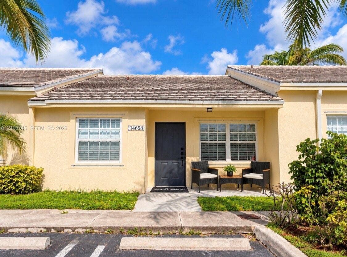 14658 SW 126th Place, Miami, FL 33186 Stucco exterior featuring a shake-style roof, covered entryway, and multi-pane windows