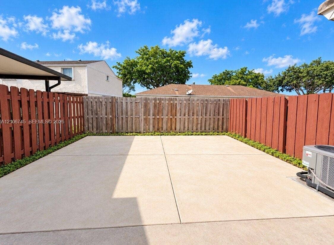 14658 SW 126th Place, Miami, FL 33186 Concrete patio enclosed by wood privacy fencing and low-profile perimeter shrubbery