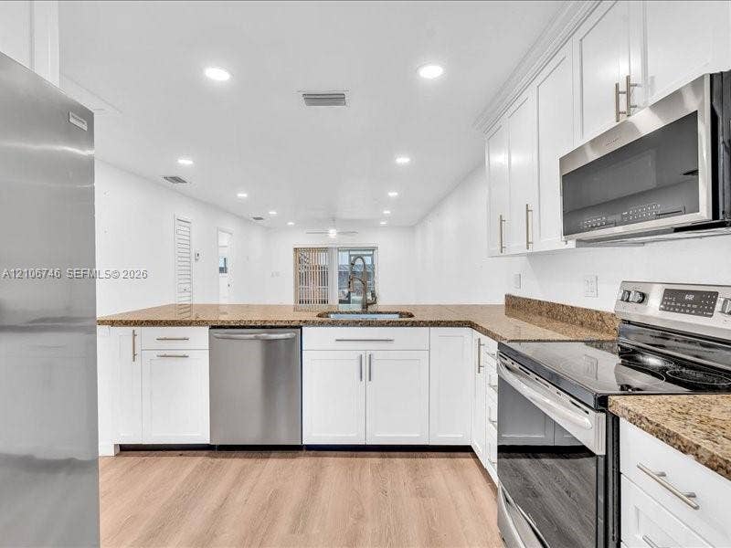 6608 SW 49th Street, #0, Davie, Davie, FL 33314 Kitchen featuring white shaker-style cabinetry, stone countertops, stainless steel appliances, recessed lighting, and wood-finish flooring
