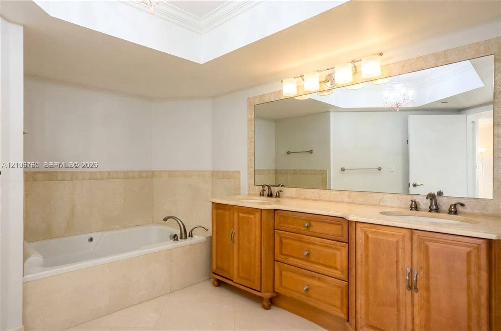 3598 Yacht Club Drive, #901, Aventura, FL 33180 Main bathroom, soaking tub with stone tile surround, dual-sink vanity with wood cabinetry, and large wall-mounted mirror