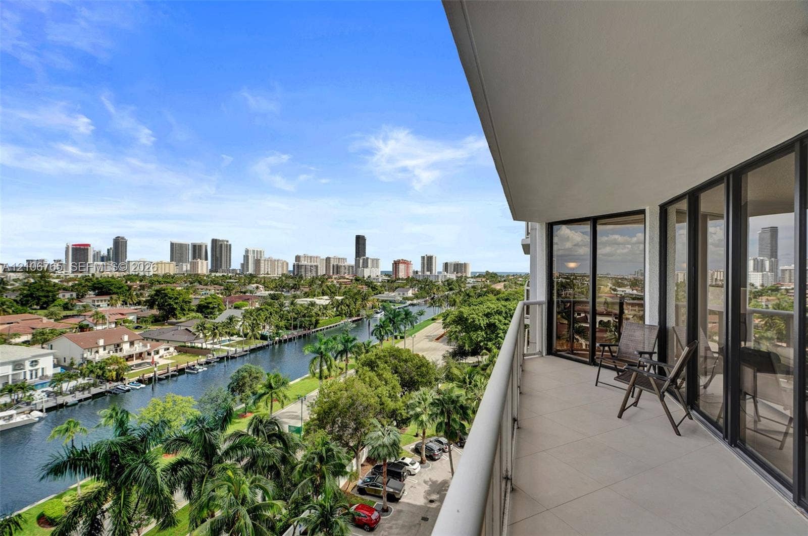 3598 Yacht Club Drive, #901, Aventura, FL 33180 Covered balcony with large-format tile flooring, glass-panel railing, and floor-to-ceiling sliding glass doors