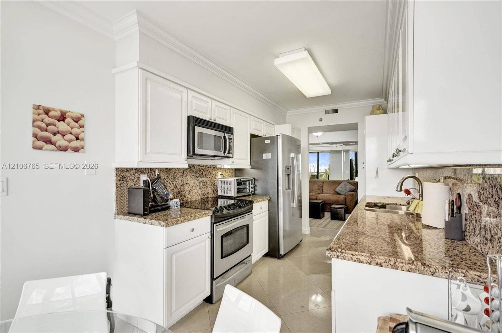 3598 Yacht Club Drive, #901, Aventura, FL 33180 White cabinetry, stone countertops, stone tile backsplash, stainless steel appliances.