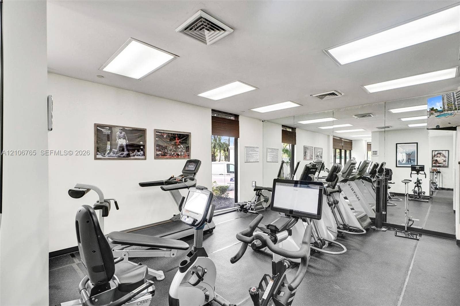 3598 Yacht Club Drive, #901, Aventura, FL 33180 Fitness space, resilient rubber flooring, expansive wall-to-wall mirrors, recessed lighting, and large windows.