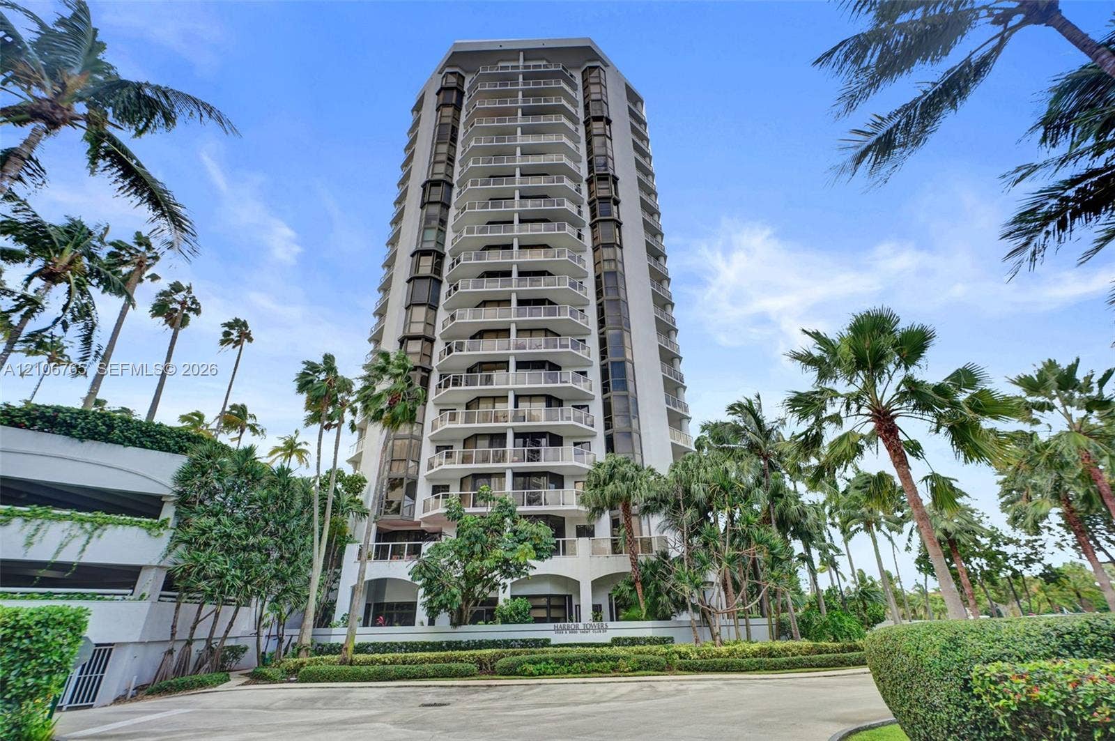 3598 Yacht Club Drive, #901, Aventura, FL 33180 High-rise building exterior featuring tiered balconies, expansive glass windows, palm tree landscaping.