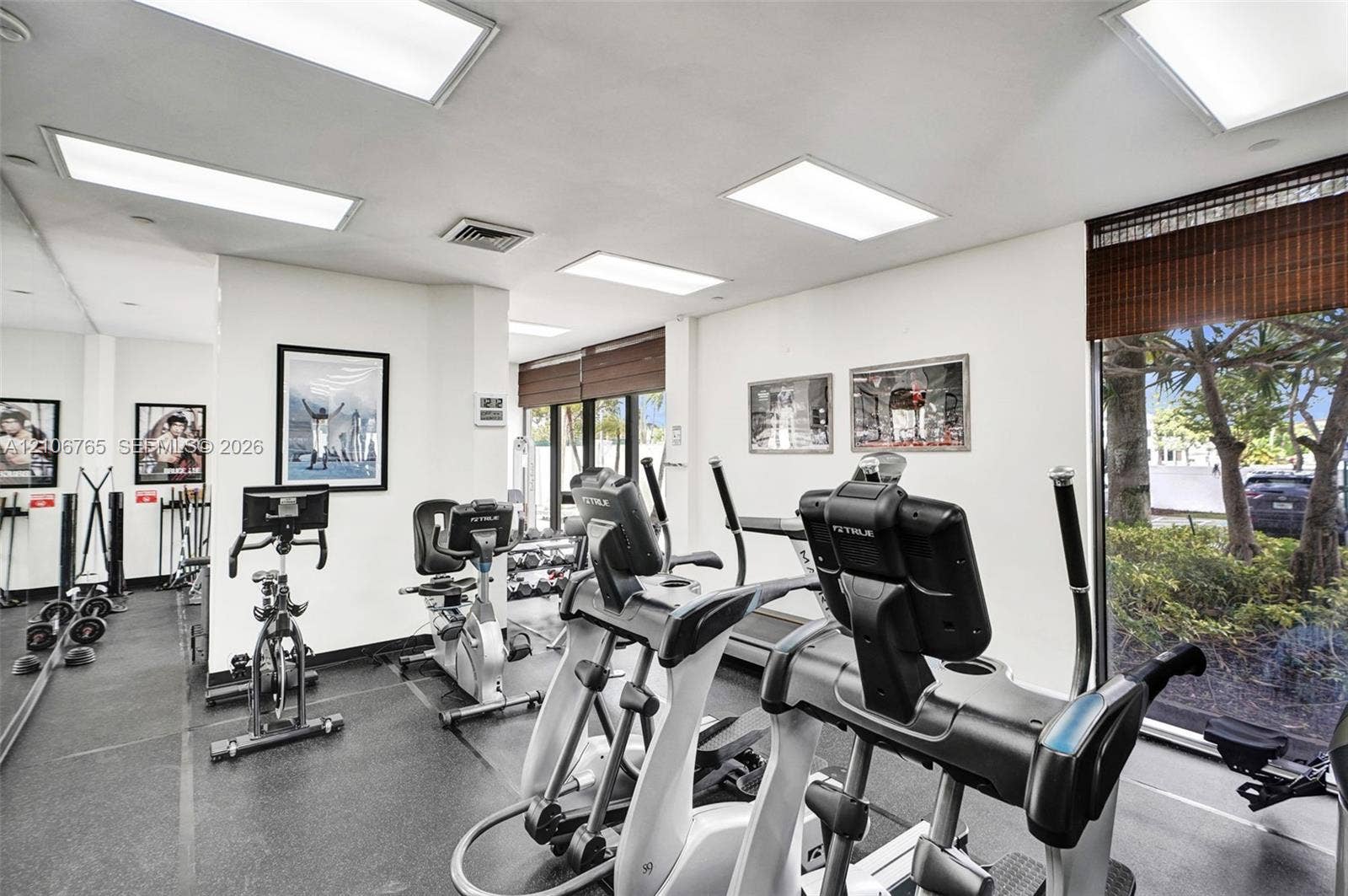 3598 Yacht Club Drive, #901, Aventura, FL 33180 Fitness center featuring recessed panel lighting, floor-to-ceiling mirror wall, and floor-to-ceiling windows with integrated window shades