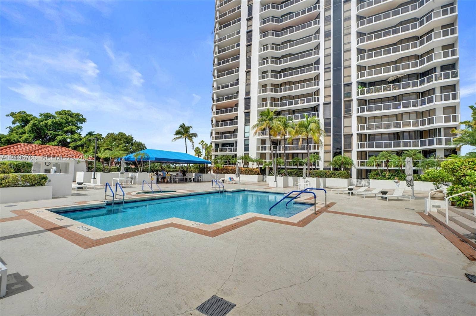 3598 Yacht Club Drive, #901, Aventura, FL 33180 Swimming pool featuring a concrete deck, built-in stair entry, attached shade structure, and surrounding landscaped grounds