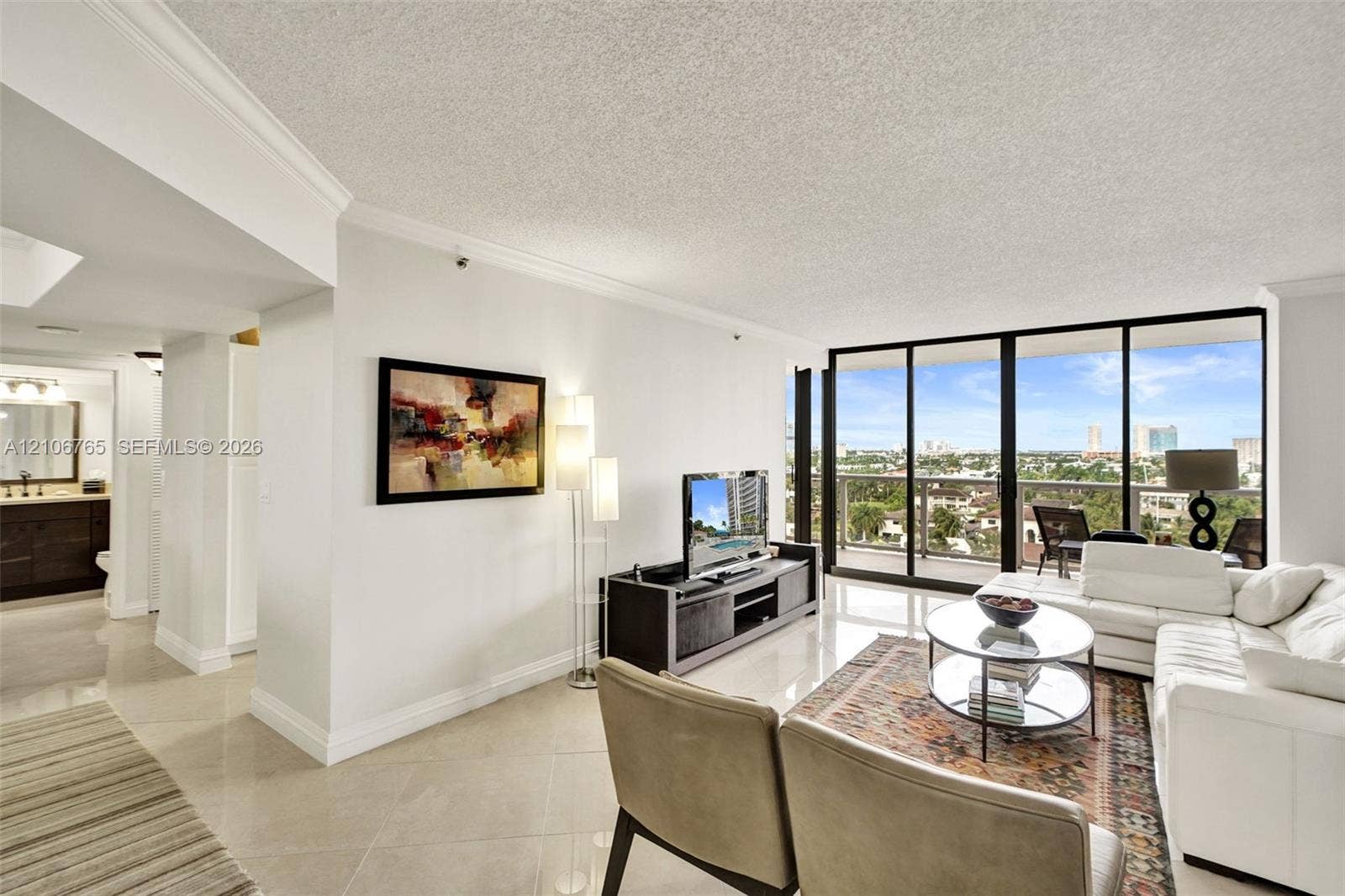 3598 Yacht Club Drive, #901, Aventura, FL 33180 Living area, large tiles, floor-to-ceiling glass sliding doors opening to an exterior balcony.