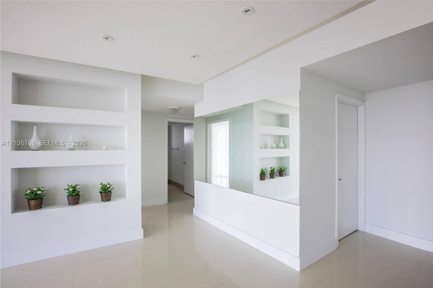 Recessed wall shelving, full-height wall mirror, smooth-finish tile flooring, and integrated recessed ceiling lighting