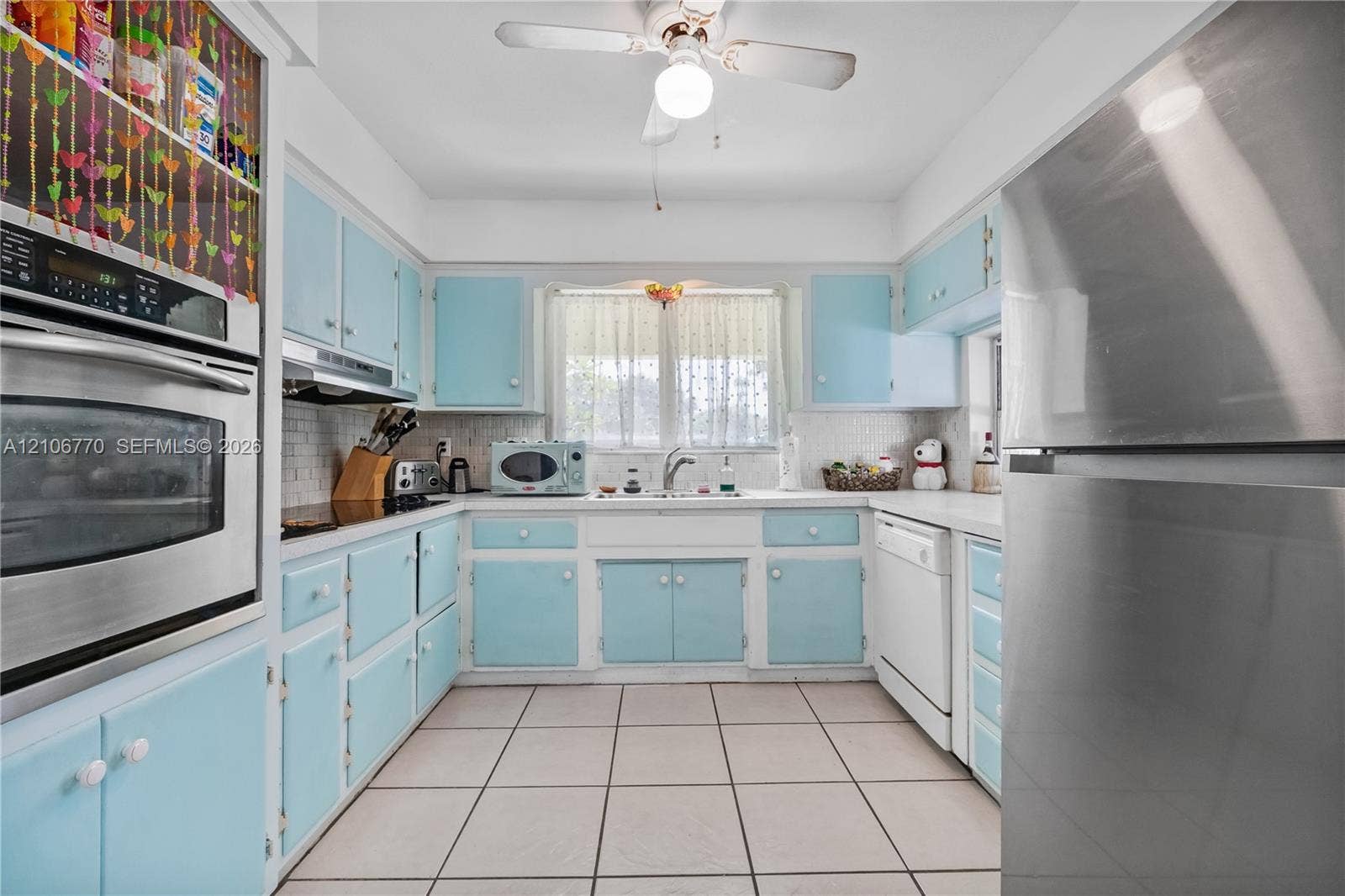 5701 SW 1st Street, Plantation, FL 33317 Kitchen featuring custom cabinetry, stainless steel oven, stainless steel refrigerator, white tiled backsplash, and ceramic tile flooring