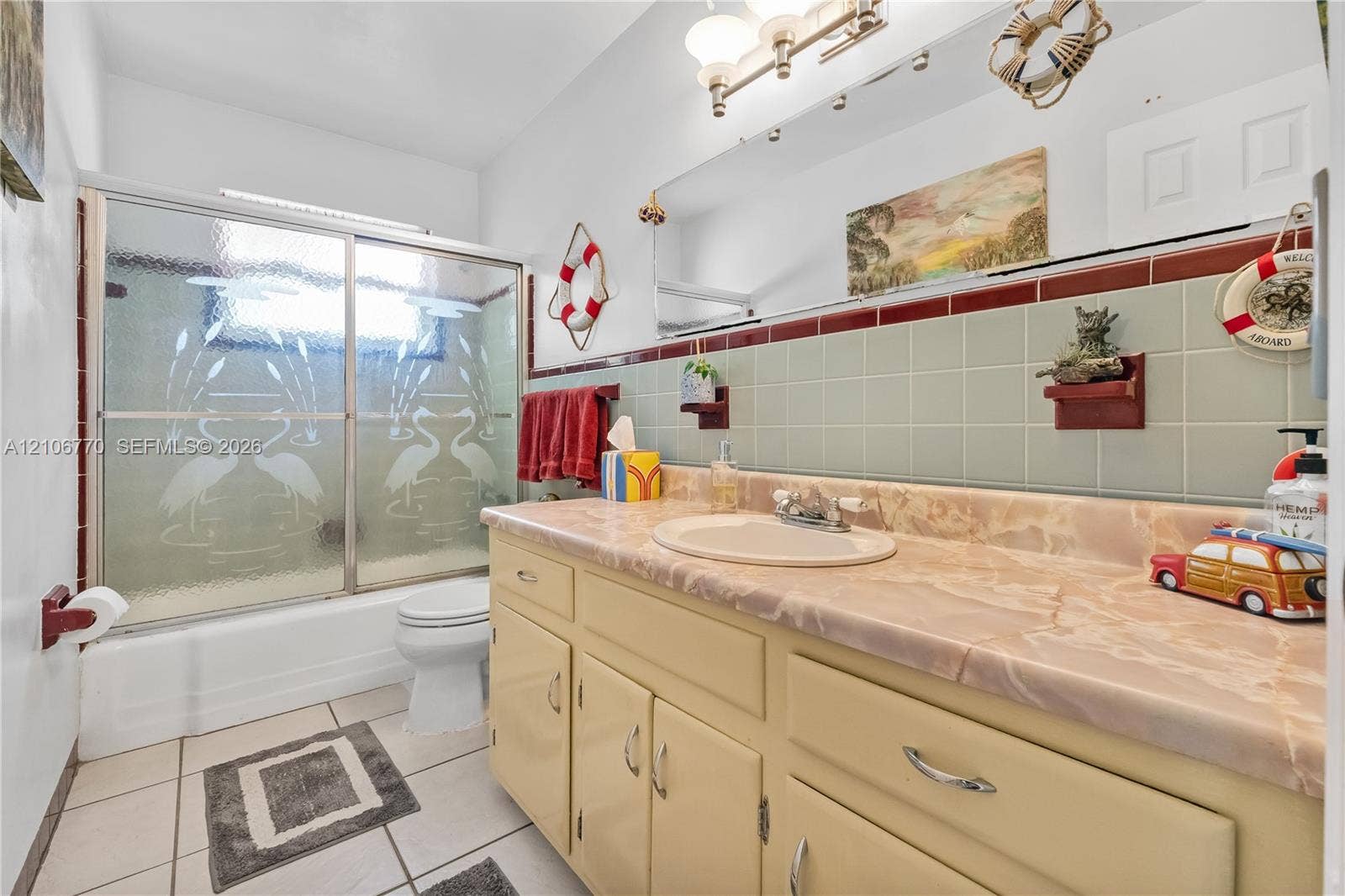 5701 SW 1st Street, Plantation, FL 33317 Bathroom featuring a stone-surface vanity with an integrated oval sink, ceramic tile wainscoting, a wall-to-wall mirror, and a tub-shower combination with sliding etched glass doors