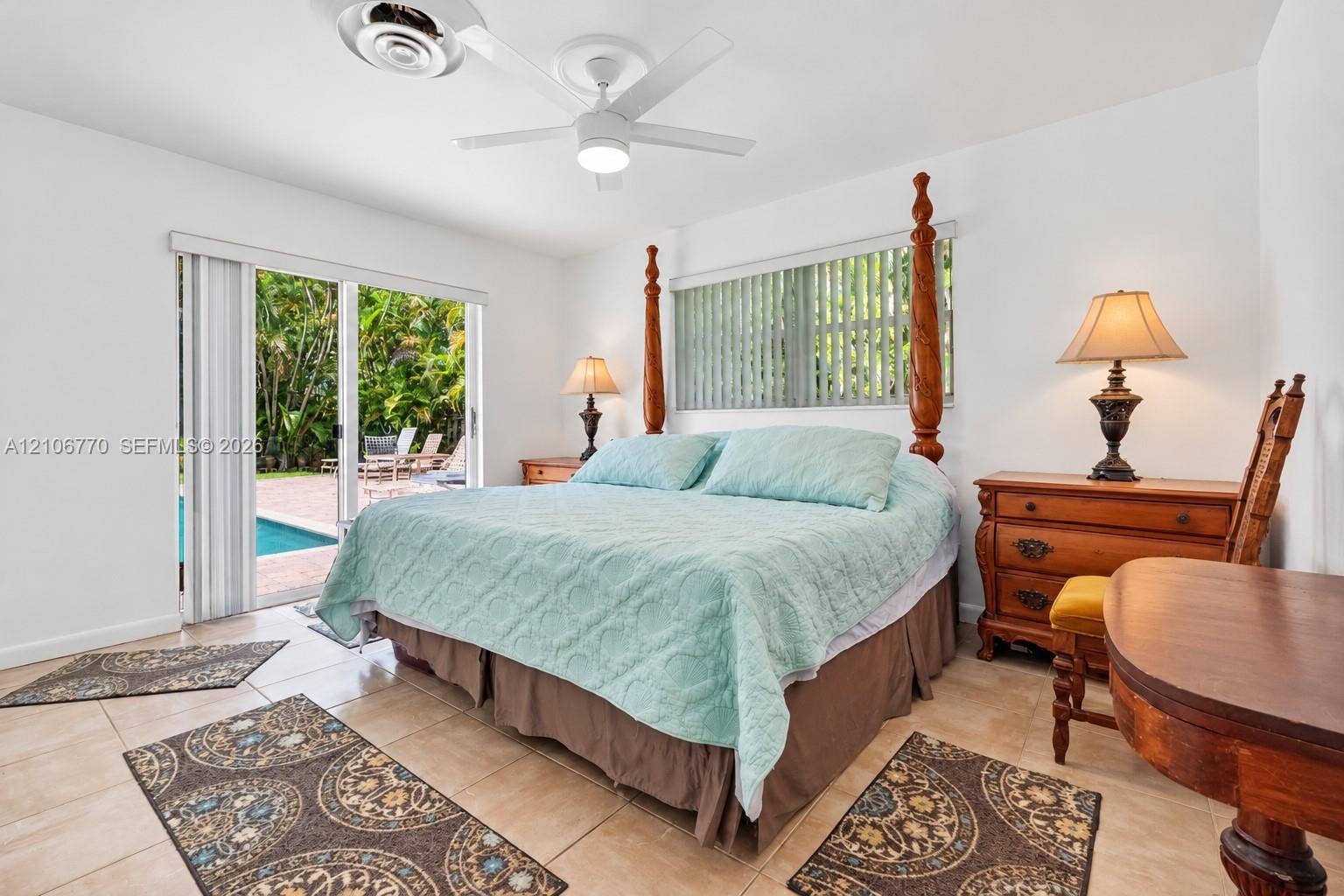 5701 SW 1st Street, Plantation, FL 33317 Neutral-tone tile flooring, white-finish ceiling fan, and sliding glass doors with access to an exterior brick-paved patio and pool area