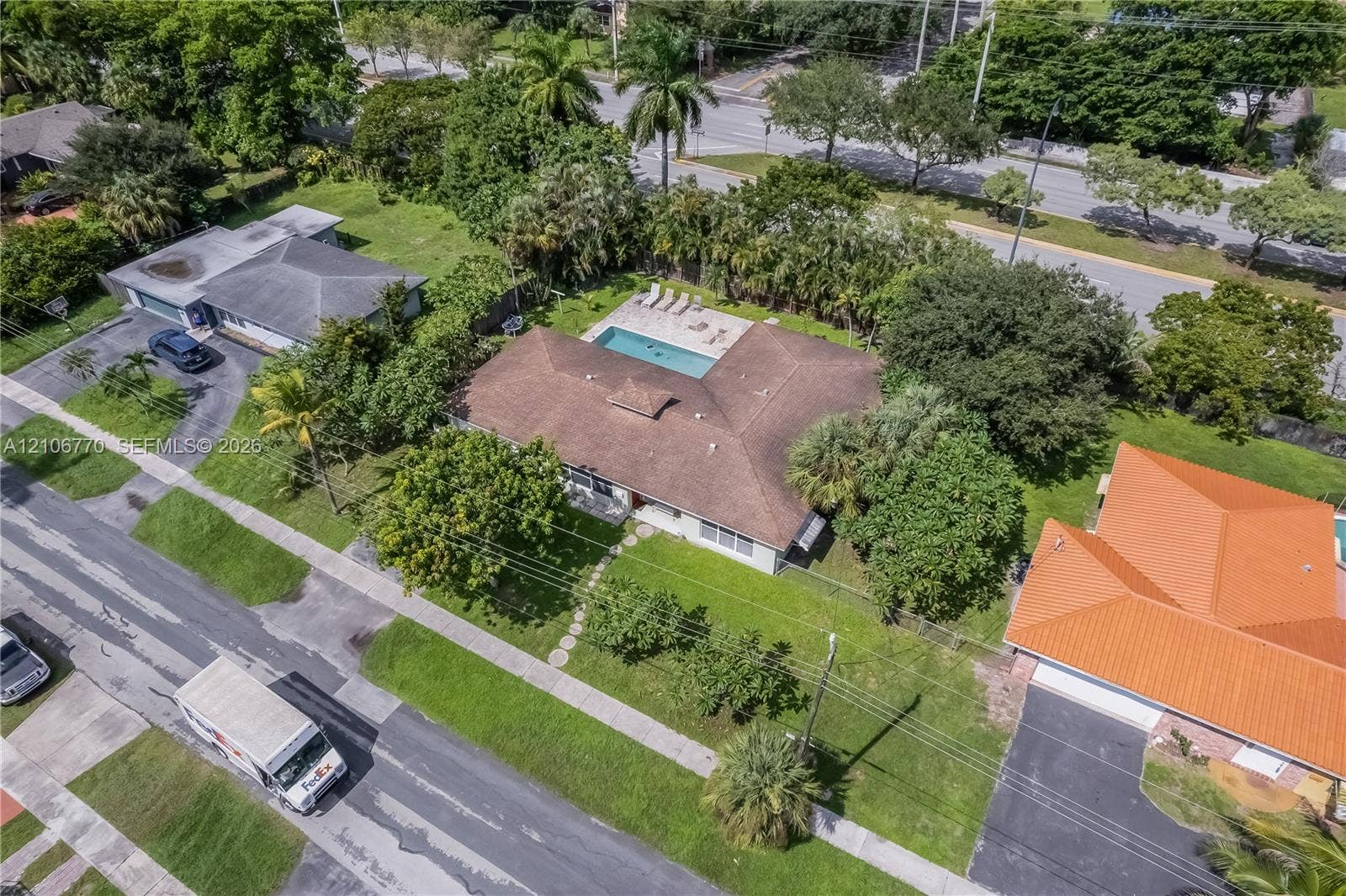 5701 SW 1st Street, Plantation, FL 33317 Aerial view of residential property featuring a hip-roof structure, in-ground swimming pool, stone-paver patio, and mature landscaping