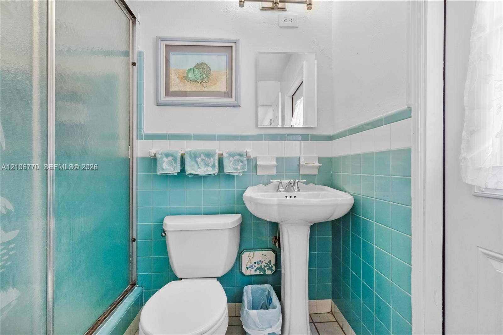 5701 SW 1st Street, Plantation, FL 33317 Bathroom featuring teal wall tiling with white accent trim, a white pedestal sink, a glass-enclosed shower, and built-in ceramic soap dishes